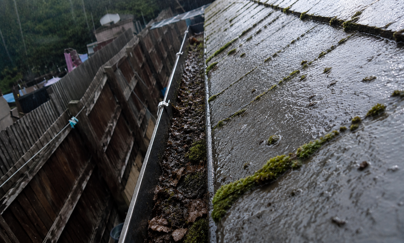Birmingham gutter before summer inspection showing hidden damage concealed beneath debris and silt